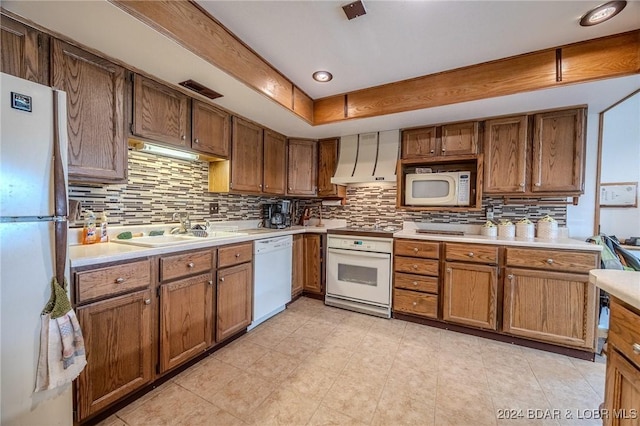 kitchen with light countertops, custom range hood, brown cabinetry, a sink, and white appliances