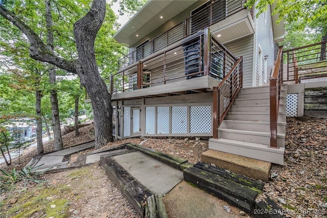 rear view of house with stairway and a wooden deck