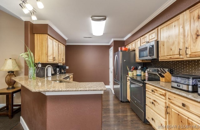 kitchen with light brown cabinets, sink, stainless steel appliances, a kitchen breakfast bar, and kitchen peninsula