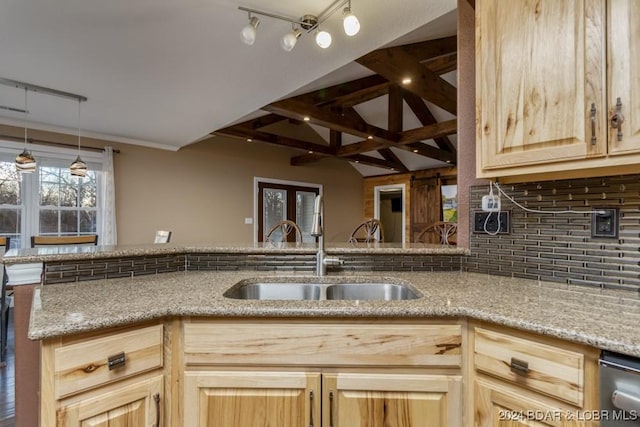 kitchen with backsplash, sink, light stone countertops, light brown cabinetry, and kitchen peninsula