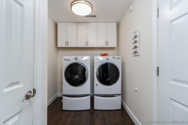 laundry room with cabinets, independent washer and dryer, and dark hardwood / wood-style flooring