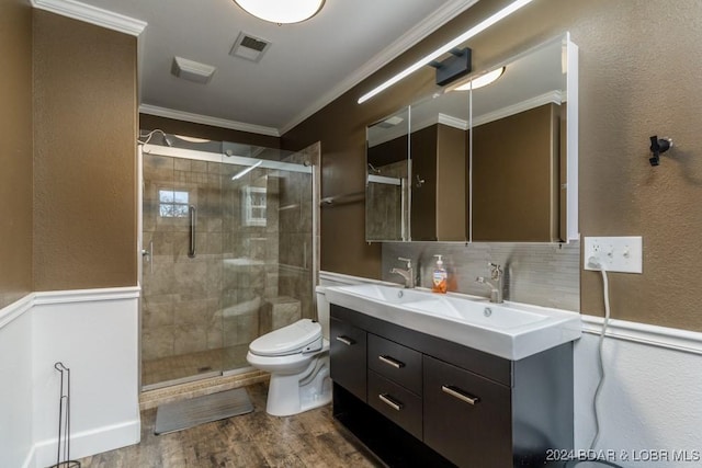 bathroom with vanity, hardwood / wood-style flooring, toilet, ornamental molding, and an enclosed shower