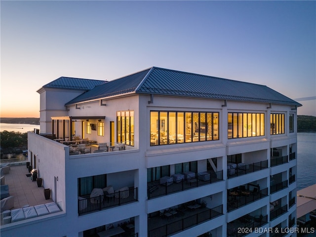 back house at dusk featuring a water view