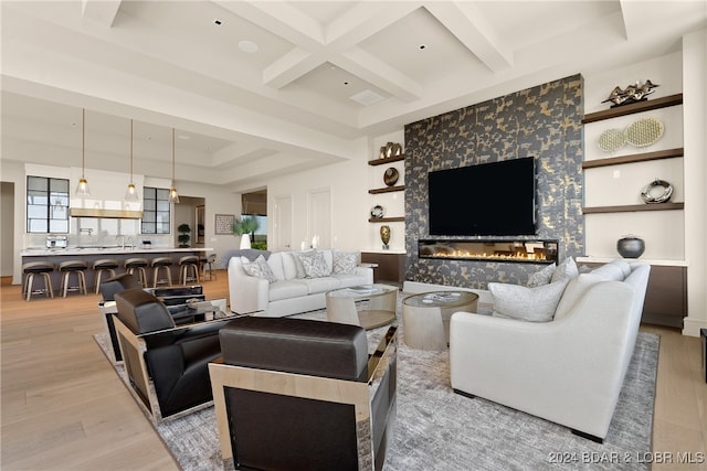 living room featuring beam ceiling, light hardwood / wood-style flooring, coffered ceiling, and sink