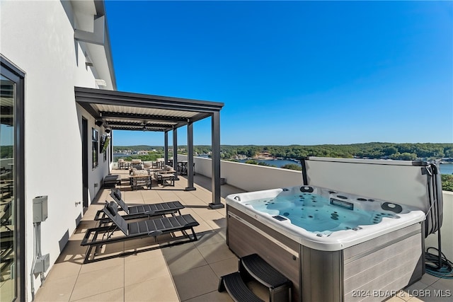 view of patio featuring a water view and a hot tub