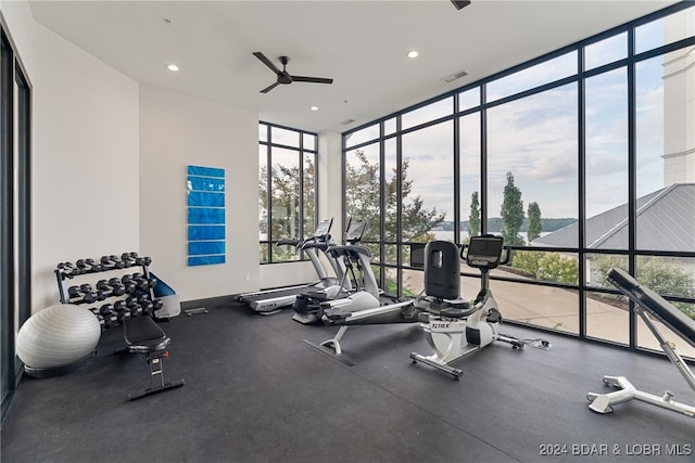 exercise room with ceiling fan and a wall of windows