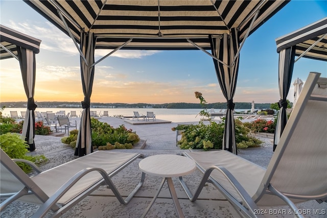 patio terrace at dusk with a gazebo and a water view