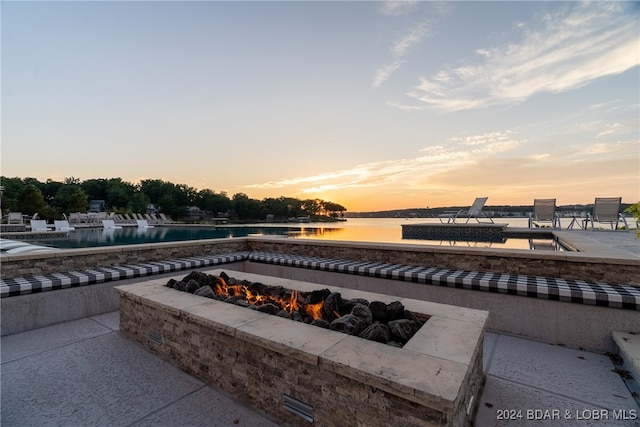 exterior space with a water view and an outdoor fire pit