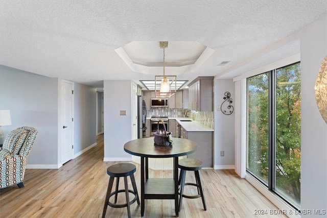 dining room with light hardwood / wood-style flooring, a wealth of natural light, and sink