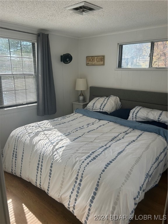 bedroom with a textured ceiling and dark hardwood / wood-style floors