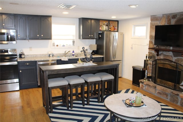 kitchen featuring a textured ceiling, stainless steel appliances, a wealth of natural light, and light hardwood / wood-style flooring