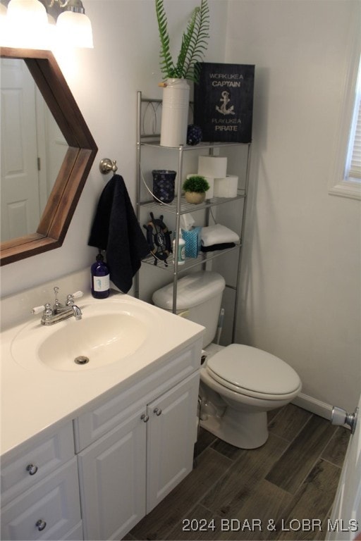 bathroom featuring vanity, hardwood / wood-style flooring, and toilet