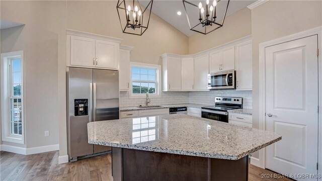 LOT1014 Enclaves Ln, Lake Ozark, MO 65049 - kitchen featuring stainless steel appliances, a sink, tasteful backsplash, white cabinetry, and high vaulted ceiling