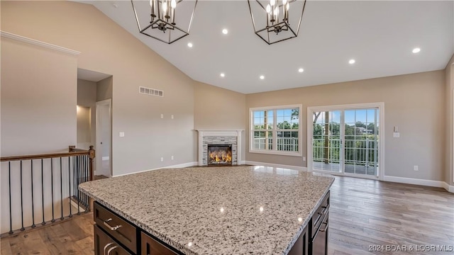 LOT1014 Enclaves Ln, Lake Ozark, MO 65049 - kitchen with a chandelier, high vaulted ceiling, open floor plan, wood finished floors, and a stone fireplace