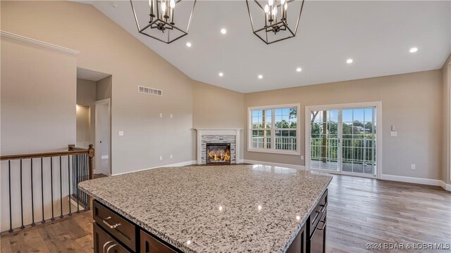 LOT1014 Enclaves Ln, Lake Ozark, MO 65049 - kitchen with a chandelier, high vaulted ceiling, open floor plan, wood finished floors, and a stone fireplace
