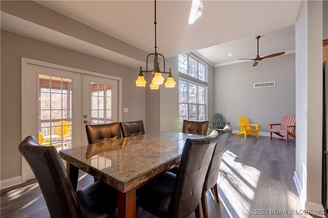 dining area featuring dark hardwood / wood-style flooring, crown molding, a wealth of natural light, and french doors