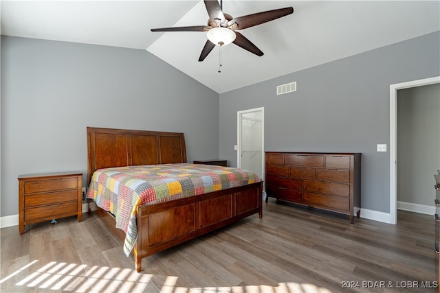 bedroom with a walk in closet, ceiling fan, hardwood / wood-style floors, a closet, and lofted ceiling