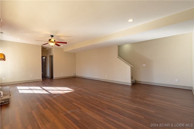 unfurnished living room featuring ceiling fan and dark hardwood / wood-style flooring