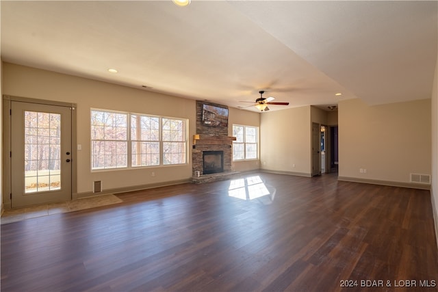 unfurnished living room with a fireplace, dark hardwood / wood-style floors, plenty of natural light, and ceiling fan