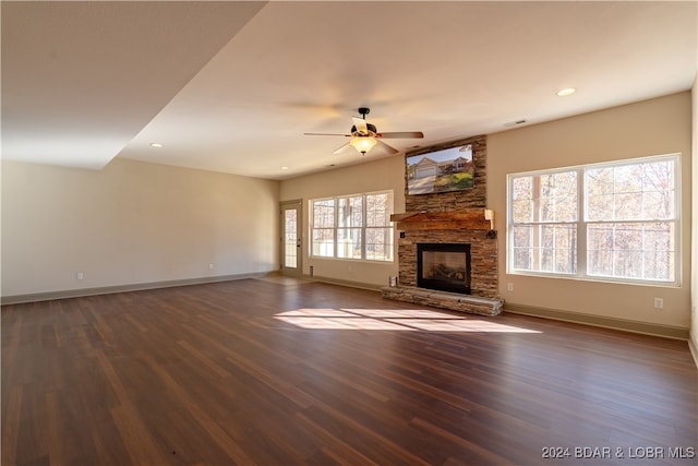 unfurnished living room with dark hardwood / wood-style floors, a healthy amount of sunlight, and a fireplace