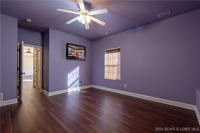 empty room with dark hardwood / wood-style flooring and ceiling fan