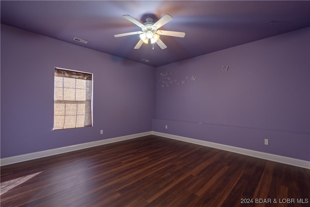 empty room with dark hardwood / wood-style floors and ceiling fan