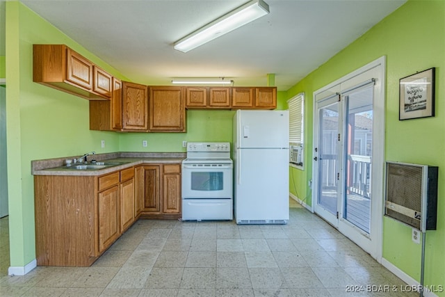 kitchen with heating unit, plenty of natural light, white appliances, and sink