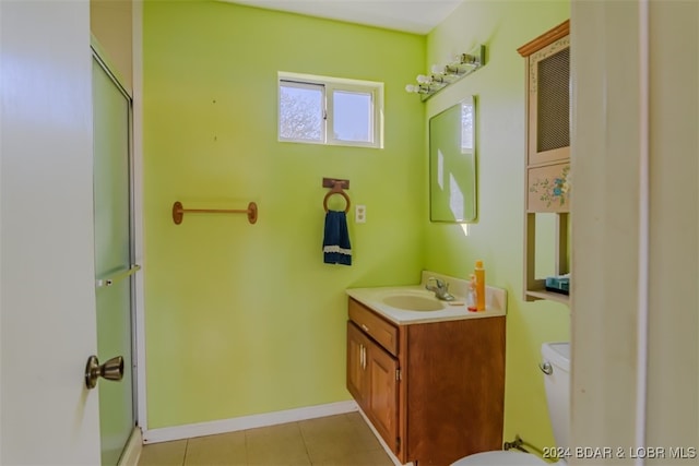 bathroom with tile patterned flooring, vanity, toilet, and a shower with shower door