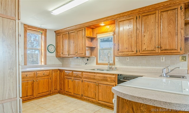 kitchen featuring tasteful backsplash, sink, and light tile patterned flooring