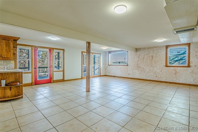 basement featuring light tile patterned flooring and sink