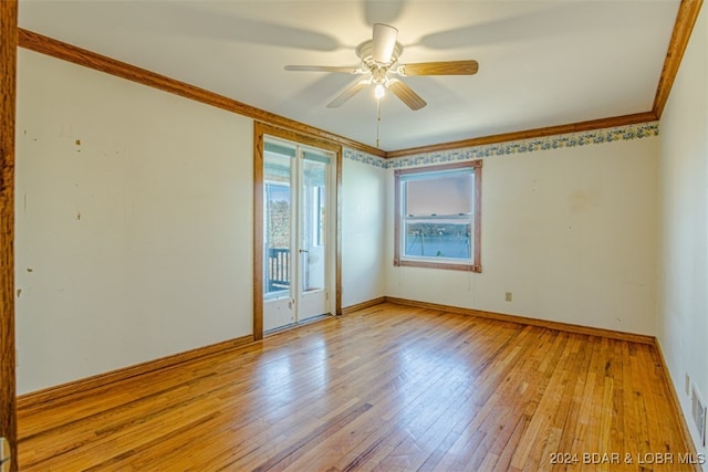 empty room featuring ceiling fan, light wood-type flooring, and ornamental molding