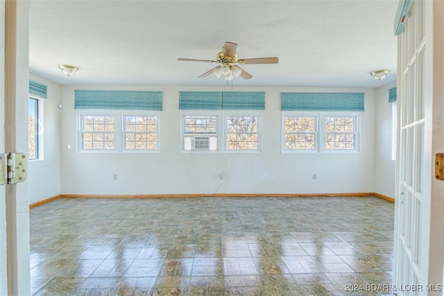 unfurnished room featuring ceiling fan and plenty of natural light