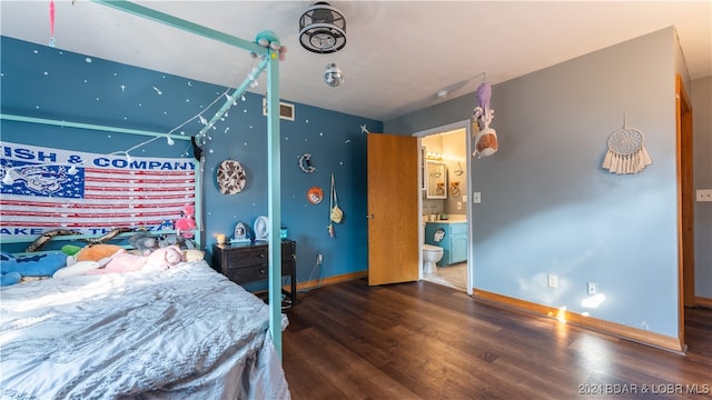 bedroom with ensuite bath and dark hardwood / wood-style floors