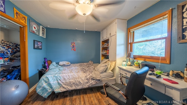 bedroom with hardwood / wood-style floors, ceiling fan, and a closet