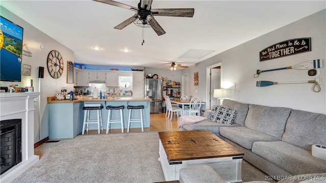 living room featuring light carpet and ceiling fan