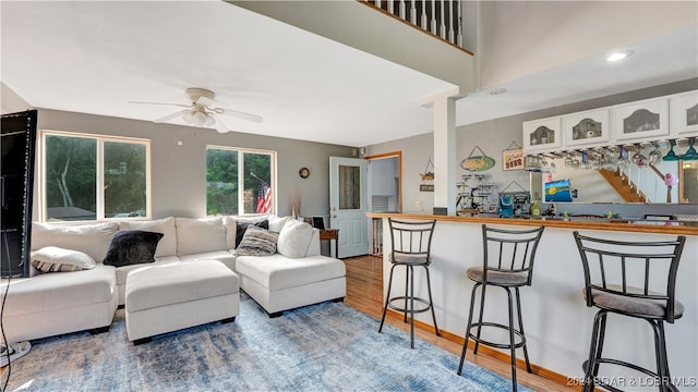 living room featuring hardwood / wood-style floors and ceiling fan