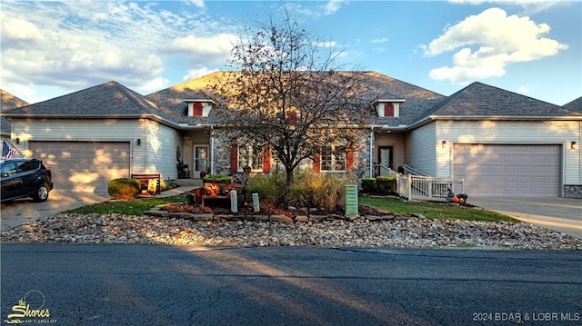 traditional home featuring concrete driveway, an attached garage, and roof with shingles