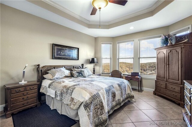 bedroom featuring ceiling fan, light tile patterned flooring, a raised ceiling, and ornamental molding