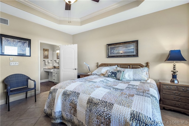 tiled bedroom featuring ceiling fan, crown molding, connected bathroom, and a tray ceiling