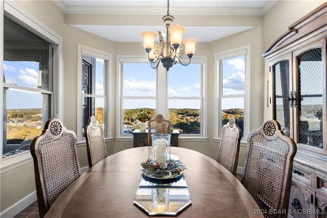 dining area featuring crown molding and an inviting chandelier