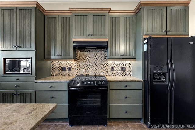 kitchen with black appliances, dark tile patterned floors, light stone countertops, and backsplash