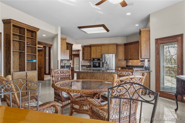 kitchen featuring kitchen peninsula, appliances with stainless steel finishes, ceiling fan, sink, and light tile patterned flooring