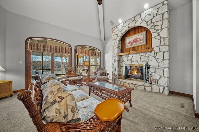 carpeted living room featuring beam ceiling, high vaulted ceiling, and a stone fireplace