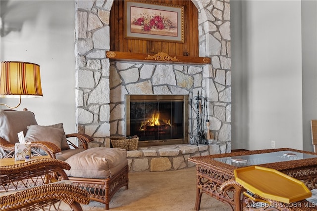 sitting room featuring a stone fireplace and carpet