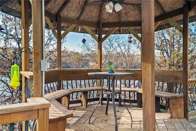 wooden terrace with a gazebo and ceiling fan