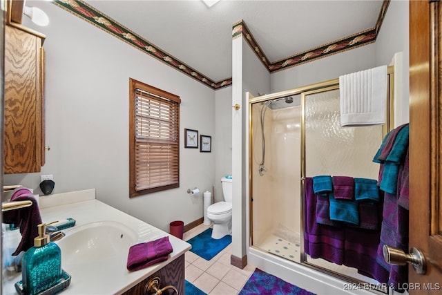 bathroom featuring tile patterned flooring, vanity, an enclosed shower, and toilet