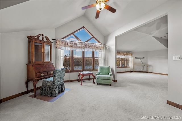 living area featuring carpet, ceiling fan, and vaulted ceiling