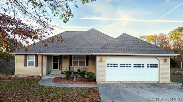 single story home featuring covered porch and a garage