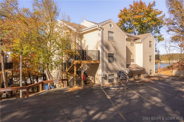 rear view of property featuring a water view and a balcony