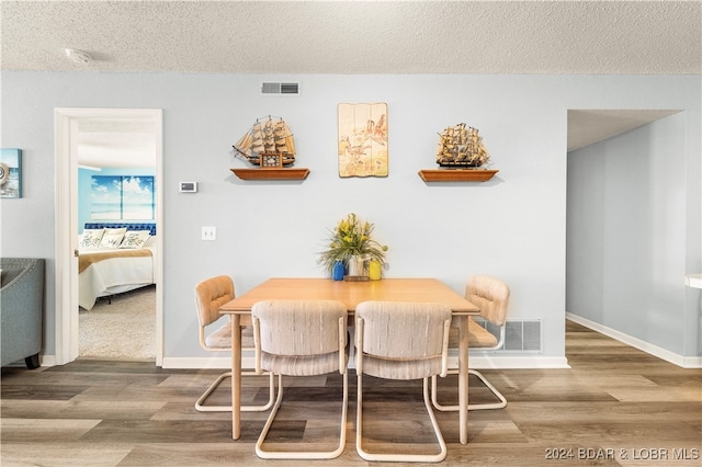 dining area featuring hardwood / wood-style floors and a textured ceiling